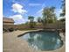 Inviting backyard pool with a rock waterfall feature, surrounded by lush landscaping at 45583 W Sheridan W Rd, Maricopa, AZ 85139
