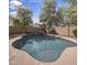 Relaxing backyard pool featuring a rock waterfall and mature palm trees, perfect for outdoor enjoyment at 45583 W Sheridan W Rd, Maricopa, AZ 85139