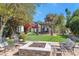 This backyard features a stone fire pit, covered patio, a small patch of artificial grass, and lush landscaping at 5431 E Lafayette Blvd, Phoenix, AZ 85018