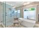 Bright bathroom featuring a modern tub, glass-enclosed shower, and stylish chandelier at 5431 E Lafayette Blvd, Phoenix, AZ 85018