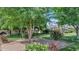 Beautiful front yard showcasing mature trees, colorful roses, and lush green grass creating a park-like setting at 5431 E Lafayette Blvd, Phoenix, AZ 85018