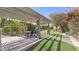 Shaded pergola offers a tranquil dining space with lush greenery and string lights for ambiance at 5431 E Lafayette Blvd, Phoenix, AZ 85018