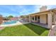 Exterior view of the backyard featuring a pebble tec pool with rock waterfall, patio, and privacy fence at 604 W Villa Rita Dr, Phoenix, AZ 85023