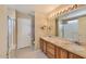 Bathroom with a double sink vanity, large mirror, shower with glass doors, and white tile flooring at 604 W Villa Rita Dr, Phoenix, AZ 85023