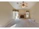 Cozy living room with brick fireplace, ceiling fan, plush carpet, and access to the backyard at 604 W Villa Rita Dr, Phoenix, AZ 85023