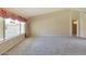A bright living room with neutral walls and carpet, large window overlooking the pool, and entry to another room at 604 W Villa Rita Dr, Phoenix, AZ 85023