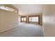 Spacious living room with plush carpeting, large windows overlooking the pool area, and neutral tones at 604 W Villa Rita Dr, Phoenix, AZ 85023