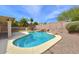 Backyard view of a private pool with a rock waterfall feature, surrounded by desert landscaping and a secure fence at 604 W Villa Rita Dr, Phoenix, AZ 85023