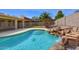 Relaxing pool with rock waterfall feature, steps, mature palms, and an adjacent patio at 604 W Villa Rita Dr, Phoenix, AZ 85023