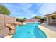 Backyard pebble tec pool features a rock waterfall, gravel landscaping, and privacy fence at 604 W Villa Rita Dr, Phoenix, AZ 85023