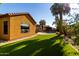 Landscaped backyard featuring a lush green lawn, and tropical trees at 6820 W Angela Dr, Glendale, AZ 85308