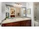 Bathroom with double vanity, white countertop, wood cabinets and a view of a shower and bathroom at 6820 W Angela Dr, Glendale, AZ 85308