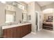 Bright bathroom with double vanity, quartz countertop, wood cabinets, and tiled floor at 6820 W Angela Dr, Glendale, AZ 85308