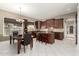 Open kitchen featuring dark wood cabinets, granite countertops, stainless appliances, island, and dining area at 6820 W Angela Dr, Glendale, AZ 85308