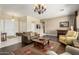 Cozy living room featuring hardwood floors, a chandelier, comfortable furniture and neutral paint at 6820 W Angela Dr, Glendale, AZ 85308