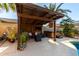Relaxing outdoor living space with a wooden pergola, comfortable seating, and a hot tub at 6820 W Angela Dr, Glendale, AZ 85308