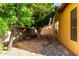 Charming side yard featuring rock landscaping and mature trees at 6820 W Angela Dr, Glendale, AZ 85308