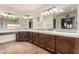 Spacious bathroom with double sinks, tile countertops, and vanity with dark wood cabinets at 7656 W Wagoner Rd, Glendale, AZ 85308