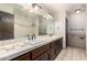 Bathroom with double sinks, white tiled countertops, and shower at 7656 W Wagoner Rd, Glendale, AZ 85308