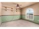 Bedroom with a ceiling fan, arched window, and two-tone walls at 7656 W Wagoner Rd, Glendale, AZ 85308