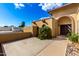 Beige home featuring an arched entry with a pair of carved, dark-wood doors at 7656 W Wagoner Rd, Glendale, AZ 85308