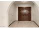 Front foyer featuring a pair of carved dark-wood doors and tile flooring at 7656 W Wagoner Rd, Glendale, AZ 85308