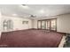 Open living room with carpet, recessed lights, and sliding doors to the exterior at 7656 W Wagoner Rd, Glendale, AZ 85308