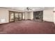Spacious living room showcasing a stone fireplace and sliding glass doors to the exterior at 7656 W Wagoner Rd, Glendale, AZ 85308