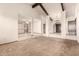 Open-concept living room with carpet, wood beams and a view to other rooms at 7656 W Wagoner Rd, Glendale, AZ 85308