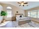 The bedroom is naturally lit with multiple windows and neutral decor and features a ceiling fan and decorative plant at 832 N Blue Marlin Dr, Gilbert, AZ 85234
