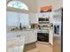 Updated kitchen features white cabinets, stainless steel appliances, granite counters, and decorative window at 832 N Blue Marlin Dr, Gilbert, AZ 85234