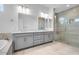 Bathroom featuring double sinks, quartz countertops, and tiled shower with a bench at 8324 W Palo Verde Dr, Glendale, AZ 85305