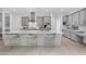 Bright, modern kitchen features gray cabinets, stainless steel appliances, and a large white center island with bar seating at 8324 W Palo Verde Dr, Glendale, AZ 85305