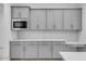 Stylish kitchen with sleek gray cabinets, stainless steel microwave, and subway tile backsplash at 8324 W Palo Verde Dr, Glendale, AZ 85305