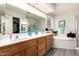 A full bathroom features a dual-sink vanity with oak cabinets, and a separate tub and shower at 8336 E Neville Ave, Mesa, AZ 85209
