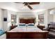 A primary bedroom suite features a dark wood bed frame, wood-look flooring and a ceiling fan at 8336 E Neville Ave, Mesa, AZ 85209