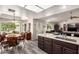 Open kitchen and dining area with island seating, hardwood floors, stainless appliances, and ample natural light at 8336 E Neville Ave, Mesa, AZ 85209