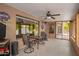 This covered patio features neutral paint, ceiling fan, outdoor seating, and a partial view of the yard at 8336 E Neville Ave, Mesa, AZ 85209