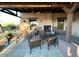 Cozy covered patio with a fireplace, comfortable seating, and views of the surrounding desert landscape at 8377 S Mountain Air Ln, Gold Canyon, AZ 85118