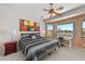 Bright primary bedroom featuring plush carpet, and an office desk with backyard view at 8377 S Mountain Air Ln, Gold Canyon, AZ 85118