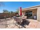 Charming backyard patio with outdoor dining set, grill, desert landscape and covered area at 8377 S Mountain Air Ln, Gold Canyon, AZ 85118