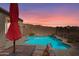 Relaxing pool area with lounge chairs, a red umbrella, and desert views in the backyard at 8377 S Mountain Air Ln, Gold Canyon, AZ 85118