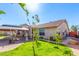 View of the backyard showcasing a covered patio, lush landscaping, and a well-maintained lawn at 9728 E Pantera Ave, Mesa, AZ 85212