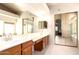 Elegant bathroom with double sinks, vanity, and mirrored closet doors provides a luxurious feel at 9728 E Pantera Ave, Mesa, AZ 85212