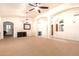 Expansive living area featuring arched doorways, neutral carpet, and modern ceiling fan at 9728 E Pantera Ave, Mesa, AZ 85212