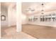 Bright living room featuring large windows, neutral carpet, and a modern ceiling fan at 9728 E Pantera Ave, Mesa, AZ 85212