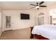Spacious main bedroom with an exterior door, a large television, and vaulted ceilings at 9728 E Pantera Ave, Mesa, AZ 85212