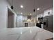 Modern kitchen with waterfall island countertop, pendant lighting, stainless steel appliances, and ample cabinet space at 1017 S Lola Ln, Tempe, AZ 85281