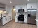 Updated kitchen with stainless steel appliances, tile backsplash, modern faucet, and ample white cabinets at 1017 S Lola Ln, Tempe, AZ 85281