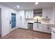 Well-lit kitchen featuring white cabinets, stainless steel appliances, and tiled floors at 1017 S Lola Ln, Tempe, AZ 85281